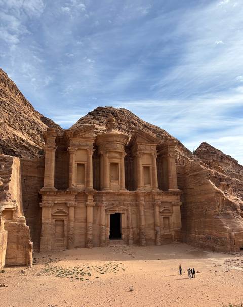       Ancient rock-carved structure with hills in the background.
  
