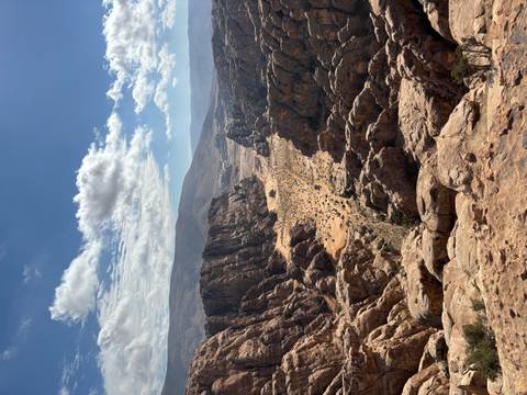       Panoramic view of a rugged canyon landscape under a blue sky.
  