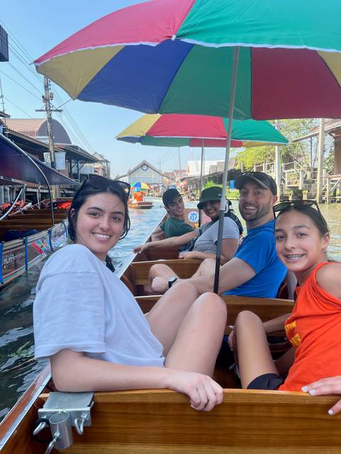 Group of people enjoying a boat ride on a canal market.