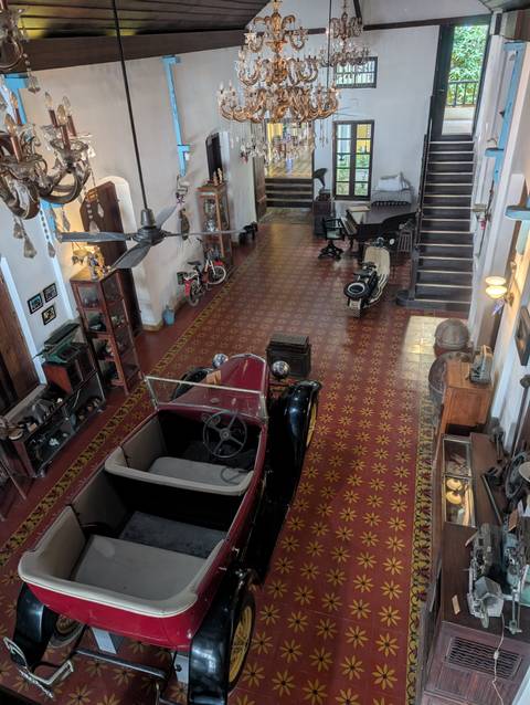       Vintage cars displayed in a room with traditional flooring.
  
