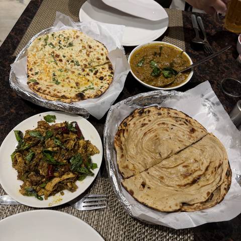       Various dishes including naan and curry laid out on a table.
  