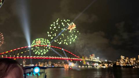 Fireworks display over a city bridge at night.