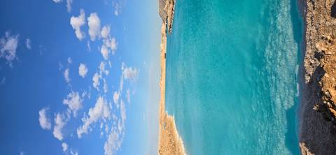 Blue water lake with clouds in the sky.