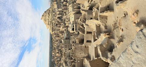 Ruined ancient city landscape with a prominent hill.