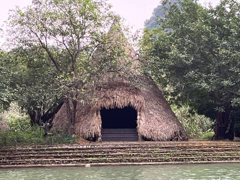 Traditional thatched hut in a natural setting.