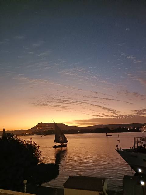       Sunset over mountains with a calm river in foreground.
  