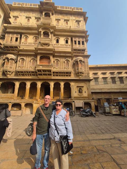       Couple standing in front of a yellow-painted historical building.
  