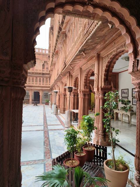       Intricately carved stone courtyard with arches and columns.
  