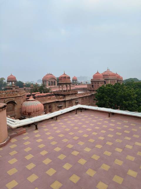       View of a palace with iconic red domes and trees in the foreground.
  