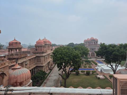       Palace complex with traditional architecture and green gardens.
  