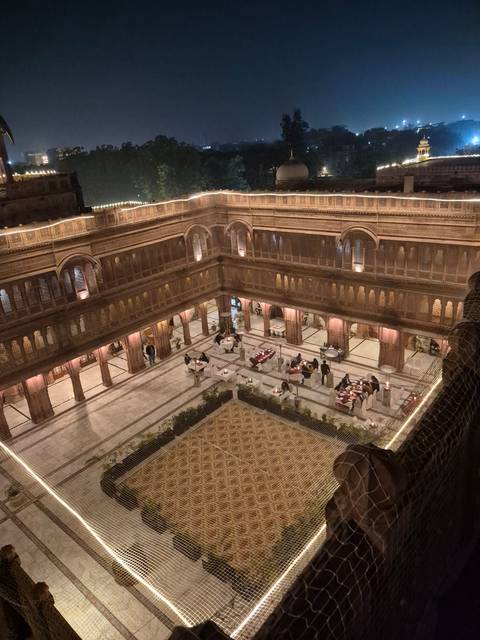       Interior view of a courtyard with tables set for dining.
  