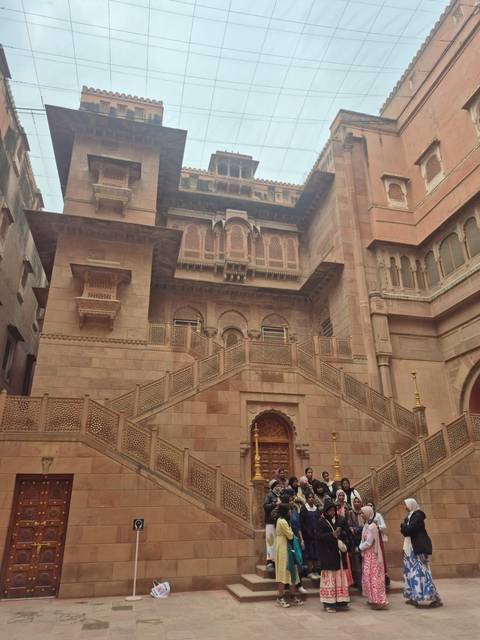       Exterior of an ornate building with intricate carvings and stairs.
  