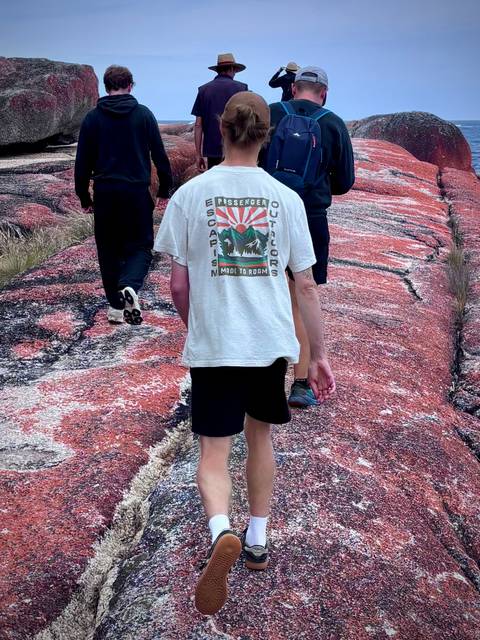 Man walking on a rocky path with others.
