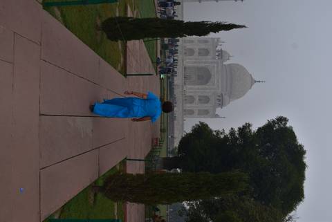 Woman walking towards the Taj Mahal in a serene setting.