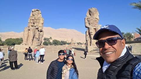 Tourists posing in front of the Colossi of Memnon.