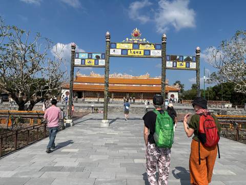      Tourists walking into a grand entrance of a historic site.
  
