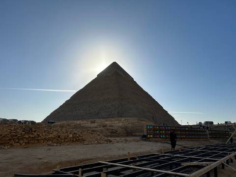       The Pyramid of Giza silhouetted against the sun.
  
