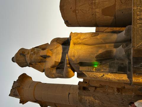       Sitting statue of an ancient pharaoh brightly lit
  