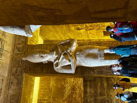       Interior of an ancient temple with tourists and hieroglyphs
  