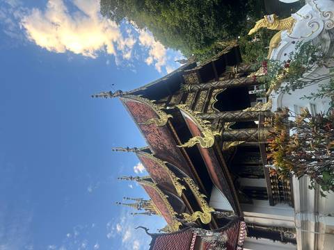 Decorative temple roof with blue sky and intricate carvings.