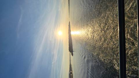 View of a wide river under a setting sun with smooth water.