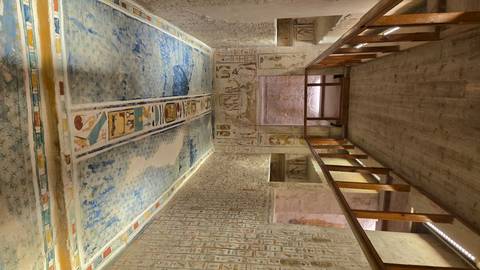 Interior of a tomb with detailed ceiling and wall art.