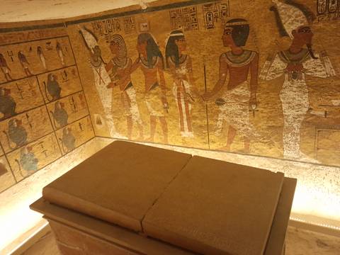       Interior of a tomb with hieroglyphics and a stone sarcophagus.
  