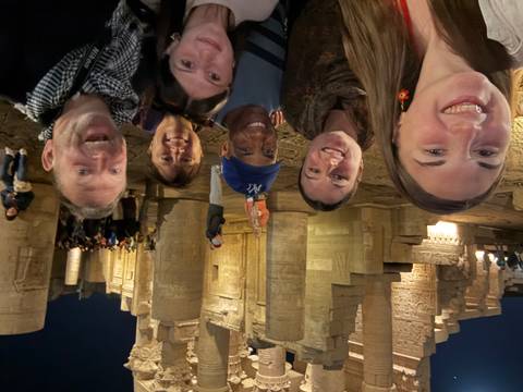 A group of people posing at a temple or historical site at night.