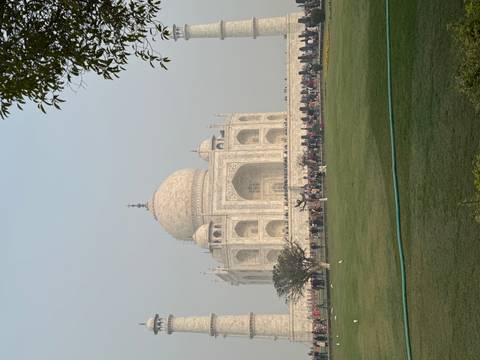 Taj Mahal with a crowd of visitors and clear sky.
