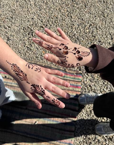       Henna designs on hands of two people.
  