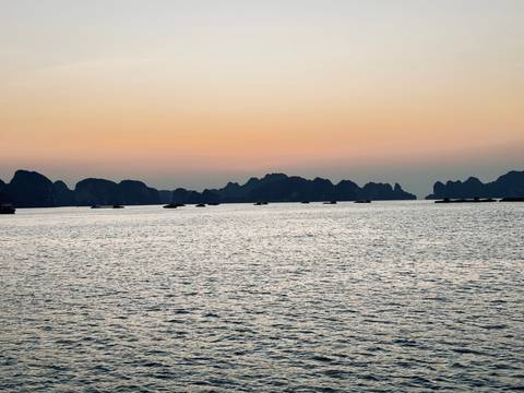 Serene view of water and distant karst formations at dusk.