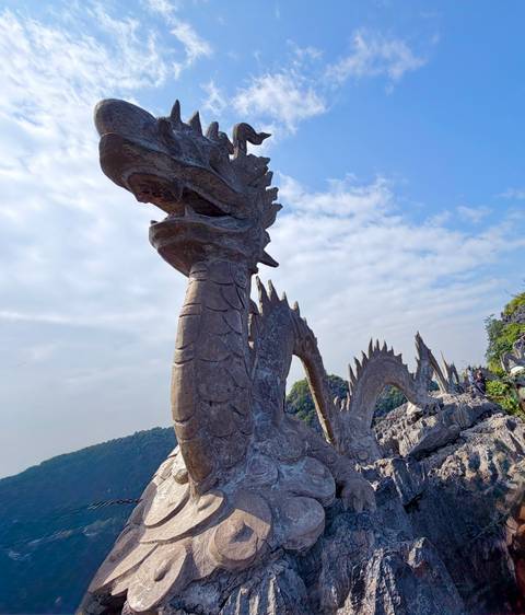       Statue of a dragon against a clear blue sky.
  