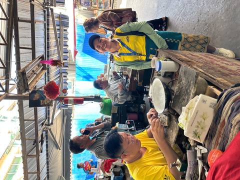 People working and displaying crafts in a bustling workshop market.