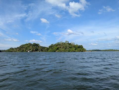 Expansive water body with lush islands under a blue sky.