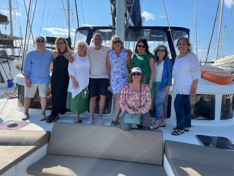       Group of people posing on a boat.
  