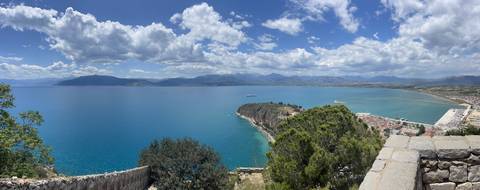       Expansive coastal view showing sea and mountains.
  