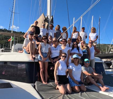       Large group of people posing on a boat deck.
  
