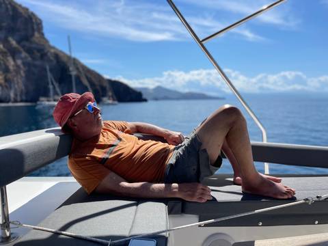       Man relaxing on a boat with a scenic view.
  