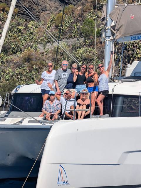       Group of people posing on a boat deck.
  