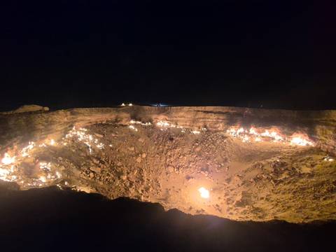 Burning crater with flames visible at night, known as the Gates of Hell.