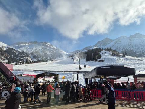 Ski resort with snowy mountains, ski lifts, and visitors.