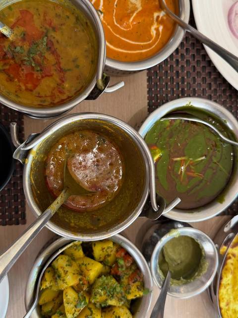 Close-up of Indian dishes in serving bowls, photographed from above.