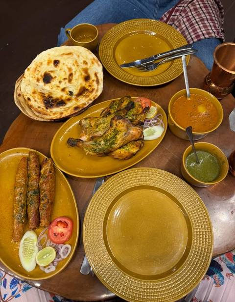       Traditional Indian meal with various dishes on a table.
  