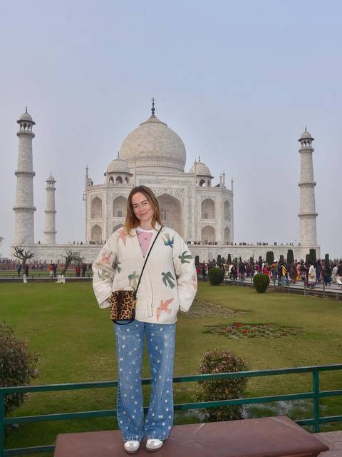       Woman standing in front of the Taj Mahal.
  
