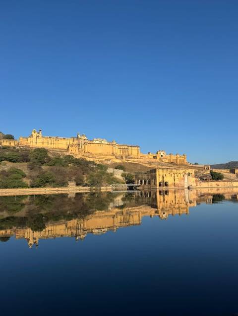       Amber fort reflecting in a lake on a clear day.
  