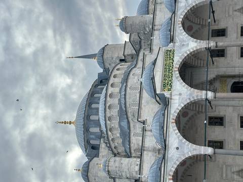 Exterior view of the Blue Mosque with cloudy skies.