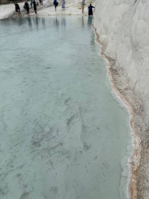       Close view of mineral deposits and water body.
  