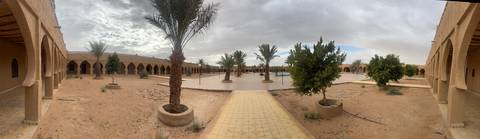 Open courtyard with palm trees surrounded by arches.