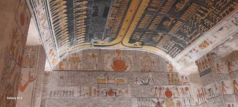 Interior view of an ancient tomb with colorful hieroglyphics.