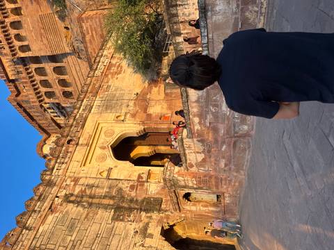 Person observing a historic fort entrance under evening light.